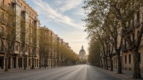 Avenida arbolada con edificios de ladrillo y una cúpula al fondo en Zaragoza